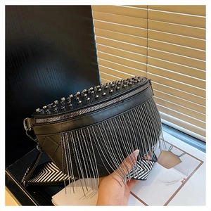 Detail of punk style black PU leather waist bag with silver rivets and metal tassels