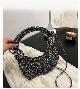 Close-up of leopard print handbag with unique knotted handle and detachable shoulder strap