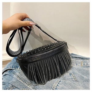 Detail of black crossbody bag featuring silver metal chain tassels and round stud accents