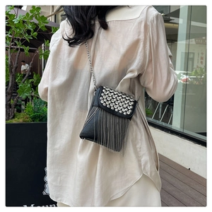 Detail showing back view of black crossbody bag with rhinestone fringes and chain strap
