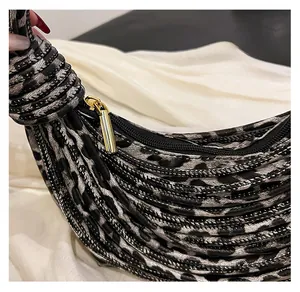 Macro shot of the smooth black zipper and leopard print fabric on the chic shoulder bag