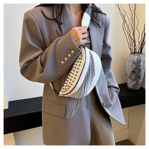 Detail of white moon bag with silver rivets, metal fringe, and striped strap