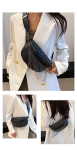 Detail of black leather chest bag with silver rivets and metal chain fringe elements