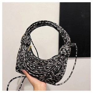 Detail of leopard print rope-woven handbag featuring round handle and gold zipper