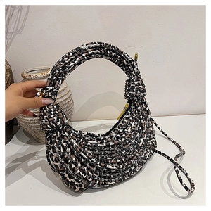 Detailed close-up of leopard print woven rope texture and knot handle on a crescent bag