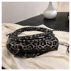 Detail of leopard print fabric and unique knotted handle on a stylish handbag