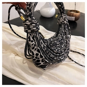Detail of leopard print woven handbag with distinctive rope texture and golden hardware