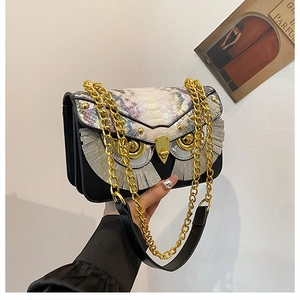 Dettaglio borsa a gufo con trama di pitone iridescente e catena in metallo oro