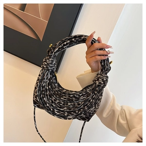 Detail of leopard print handbag with unique rope-braided handle and golden zipper