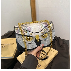 Dettaglio borsa a civetta con borchie dorate, nappe argentate e motivo a serpente colorato