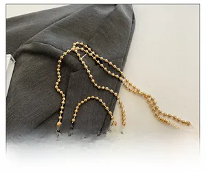 Gros plan sur la bandoulière en perles dorées avec un grand pendentif étoile en strass