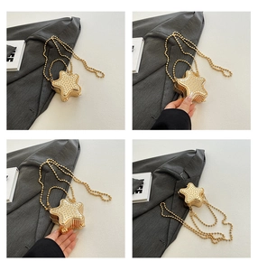 Détail d'une pochette dorée en forme d'étoile avec strass et chaînes perlées élégantes