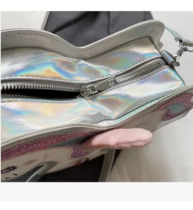 Dettaglio della cerniera in metallo argentato su borsa a tracolla olografica arcobaleno