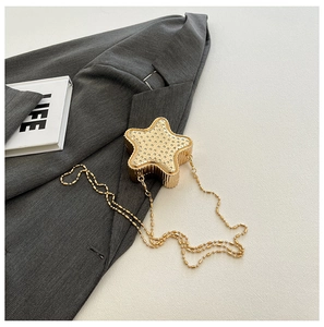 Détail d'une pochette de soirée dorée en forme d'étoile avec des strass chic
