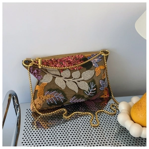 Close-up of intricate floral embroidery and sequins on vintage chain envelope bag