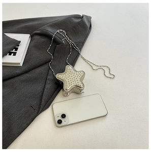 Détail d'un mini sac étoile argenté orné de strass avec une bandoulière en chaîne billes