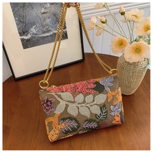 Close-up of bohemian embroidered shoulder bag with colorful floral sequins and gold chains
