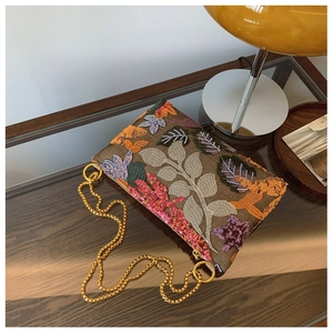 Detail of vintage floral embroidery and sparkling sequins on the brown chain bag