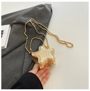 Gros plan sur le sac de soirée doré en forme d'étoile avec strass et chaîne en métal