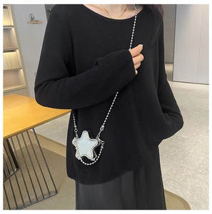 Mini sac de soirée en forme d'étoile avec chaîne en perles sur pull noir en tricot