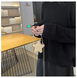 Détail du mini sac en forme d'étoile avec perles blanches et chaîne en métal doré