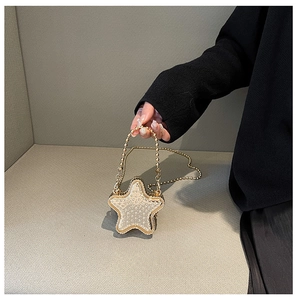 Détail d'un sac de soirée en forme d'étoile avec strass et chaîne dorée
