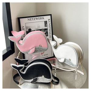 Trois sacs à bandoulière créatifs en forme de baleine en rose, blanc et noir sur socle