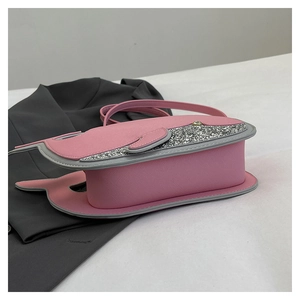 Vue détaillée d'un sac à bandoulière rose en forme de baleine avec paillettes et œil en strass
