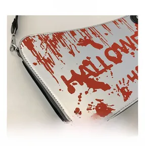 Macro shot of silver leather Halloween bag with red blood splatter and text detail