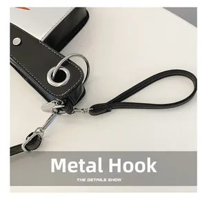 Macro detail of silver metal hook and black PU leather handle on quirky bag