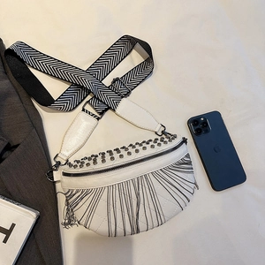 White PU fringe waist bag with rivets and chevron strap on a stylish blazer background