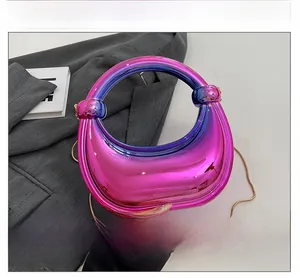 Détail d'une pochette en acrylique dégradé avec chaîne dorée et poignée nouée