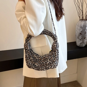 Leopard print crossbody bag with knotted handle shown on model in a white suit