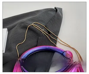 Détail du sac en acrylique avec poignée dégradée violette et bandoulière chaîne dorée