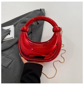 Détail du sac croissant rouge métallisé avec poignée anneau et chaîne dorée