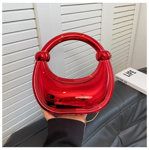 Détail du sac boîte en acrylique rouge avec fini miroir et poignée à joint sphérique