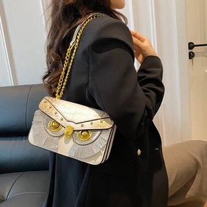 Borsa a forma di gufo bianca con trama coccodrillo e dettagli dorati indossata