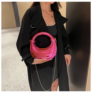 Détail du sac croissant rose métallisé avec poignée ronde et chaîne en métal