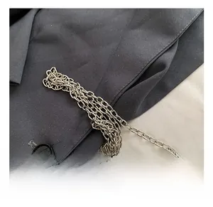 Detailed view of glossy silver metal chain strap on minimalist acrylic clutch bag
