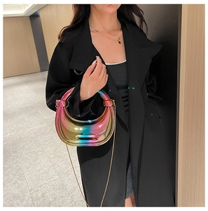 Détail du sac bandoulière en acrylique irisé avec chaîne dorée et poignée anneau chic