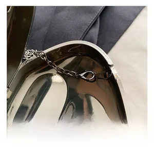 Detail view of the metal evening bag featuring a sturdy chain strap and secure clasp