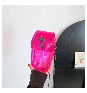 Dettaglio borsa a bara rosa trasparente in PVC con croce e borchie metalliche