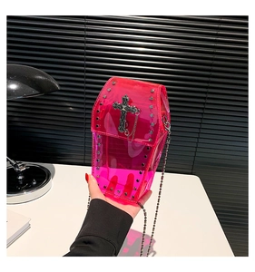 Dettaglio borsa a bara rosa in PVC trasparente con borchie e ciondolo a croce gotica