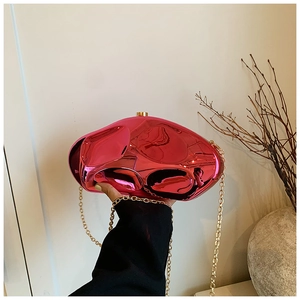 Detail of rose pink metallic acrylic stone bag with gold chain strap in hand
