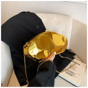 Detail of gold irregular mirror clutch bag with chain strap on black blazer
