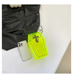 Dettaglio della borsa a bara giallo neon con croce gotica in metallo e borchie laterali