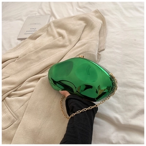 Close-up of emerald green mirror acrylic clutch bag with irregular stone-like texture