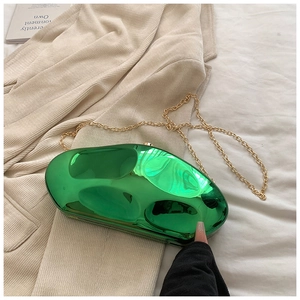 Close-up of bright green irregular stone-shaped acrylic evening bag with gold chain