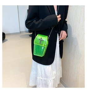 Dettaglio della borsa a bara trasparente verde neon con croce e catena metallica