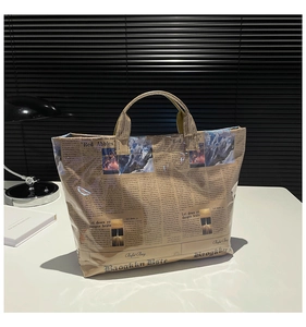 Detail of vintage newspaper print tote bag featuring waterproof PVC finish and sturdy handles